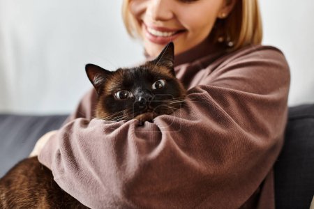A woman with short hair lovingly holds a cat in her arms, sharing a peaceful moment of companionship and affection at home.