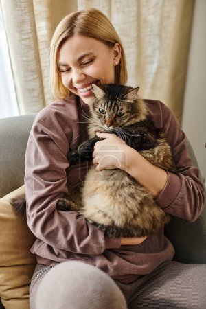 Una mujer con el pelo corto tranquilamente se sienta en un sofá mientras sostiene a su gato, compartiendo un momento de afecto y satisfacción.