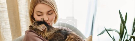 Photo for A woman relaxes on a couch while tenderly holding her cat in a quiet and peaceful setting at home. - Royalty Free Image
