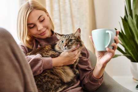 A woman with short hair sits on a couch, holding her cat lovingly.