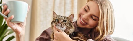 Téléchargez les photos : Une femme aux cheveux courts souriant alors qu'elle tient un chat dans ses bras, montrant un lien réconfortant entre eux. - en image libre de droit