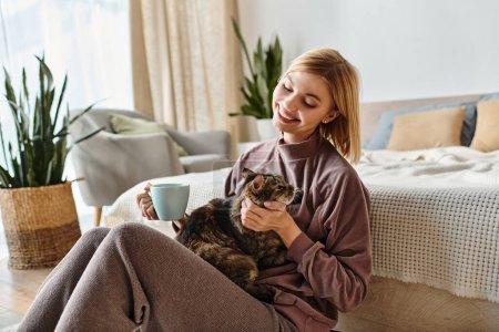 Una mujer con el pelo corto se sienta en un sofá, sujetando suavemente a su gato cerca en una escena cálida y reconfortante en casa.