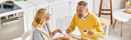 Una pareja madura disfrutando de una comida juntos en una mesa en ropa de casa acogedora, saboreando deliciosa comida en un ambiente cálido.