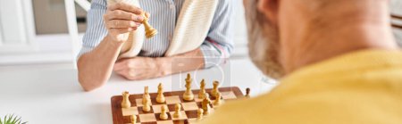 Ein Mann in kuscheliger Hauskleidung führt ein strategisches Schachspiel mit einer riesigen Banane in einer skurrilen und surrealen Umgebung zu Hause durch..
