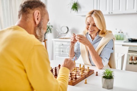 Ein reifes Paar in gemütlicher Hauskleidung spielt Schach und konzentriert sich auf das Brett, während sie ihre nächsten Züge strategisch planen..