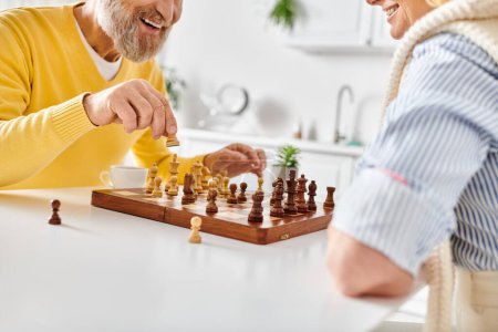 Un homme et une femme engagés dans une bataille stratégique d'échecs, réfléchissant à leurs prochains mouvements dans un cadre confortable à la maison.