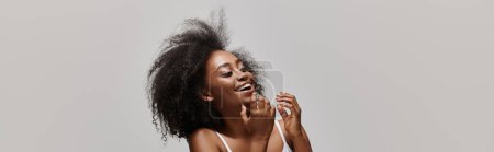 Téléchargez les photos : Une jeune afro-américaine aux cheveux bouclés portant un bikini en studio. - en image libre de droit