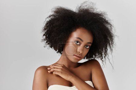 Foto de Una impresionante joven afroamericana con un peinado afro rizado posando en un estudio. - Imagen libre de derechos