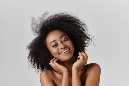 Photo for A stunning African American woman with an afro is confidently posing for a portrait in a studio setting. - Royalty Free Image