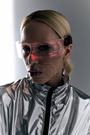 extraordinary woman with sci fi glasses in robotic silver clothing looking at camera on backdrop