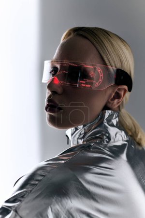 extraordinary woman with sci fi glasses in robotic clothing looking at camera on gray backdrop