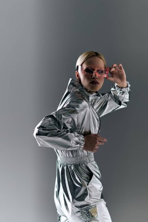 bizarre Frau mit Science-Fiction-Brille in futuristischer Kleidung, die Roboterbewegungen macht und in die Kamera schaut