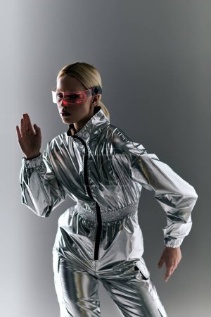 außergewöhnliche Frau mit futuristischer Brille in silberner Kleidung, die Roboterbewegungen macht und wegschaut