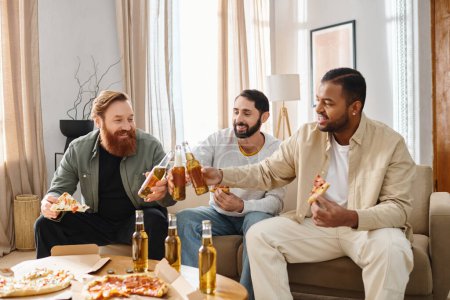 Tres hombres alegres e interraciales sentados en un sofá, disfrutando de pizza y cerveza en un ambiente informal en casa.