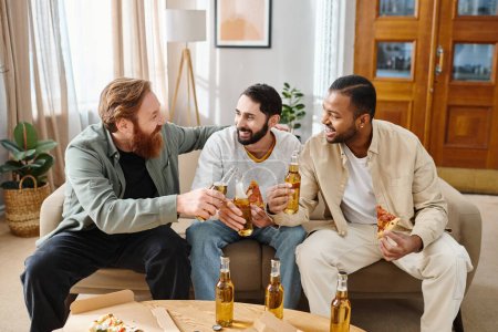 Drei glückliche Männer verschiedener Rassen genießen Bier und Pizza auf einer Couch in legerer Kleidung und feiern ihre Freundschaft.