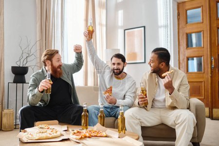 Three handsome men of different races sit on a couch, enjoying pizza and beer together in a casual, friendly atmosphere.