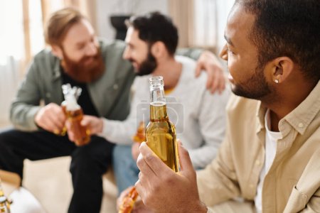 Trois hommes gais et interracial en tenue décontractée assis autour d'une table, collant sur des bières et profitant d'un bon moment ensemble.