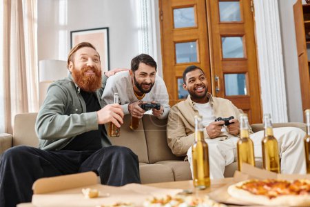 Three handsome men of different races share smiles and conversation around a table filled with pizza and beer, enjoying a relaxed evening of friendship at home.