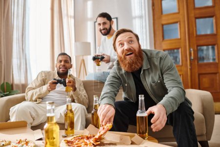 Foto de Tres hombres alegres, guapos e interraciales con atuendo casual sentados alrededor de una mesa, comiendo pizza felizmente juntos. - Imagen libre de derechos