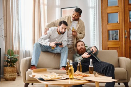 Téléchargez les photos : Deux hommes de races différentes sont assis sur un canapé, concentrés et engagés dans un jeu vidéo, leurs expressions montrant l'excitation et la camaraderie. - en image libre de droit
