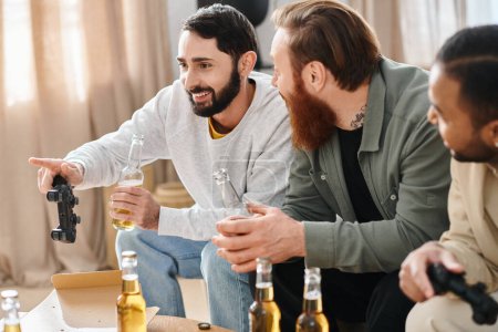 Three cheerful, interracial men enjoy a casual gathering, laughing and chatting over bottles of beer on a table.