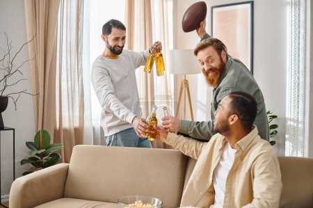 Dos hombres, uno sosteniendo una botella de cerveza, se sientan en un sofá acogedor, charlando y riendo con su atuendo casual.