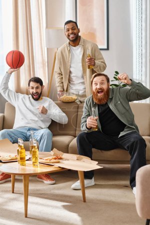 Three cheerful, handsome men of different races enjoy each others company in a cozy living room, showcasing friendship and relaxation.
