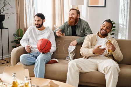 Tres amigos alegres e interraciales se sientan juntos en un sofá con atuendo casual, disfrutando de un gran momento en casa.