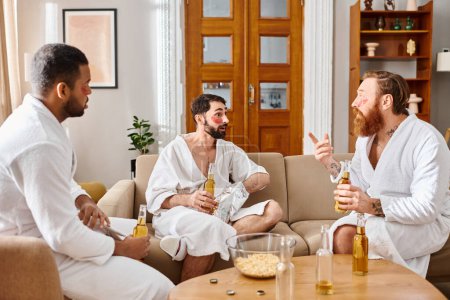 Diverse, happy men in bathrobes are seated atop a cozy couch, enjoying each others company.