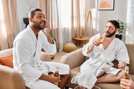 Three diverse, cheerful men in bathrobes enjoying a great time sitting atop a plush couch, sharing laughs and stories.