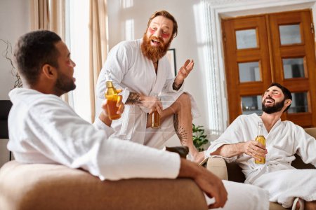 Tres hombres alegres de diversos orígenes comparten risas en una acogedora sala de estar mientras usan albornoces.