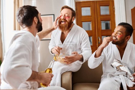 Three cheerful, diverse men wearing bathrobes sharing a moment of togetherness and friendship.