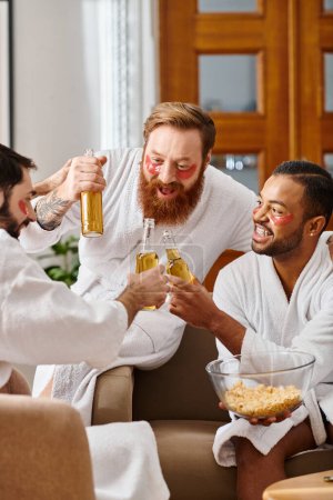 Three diverse cheerful men in bathrobes enjoying wine and camaraderie around a table.