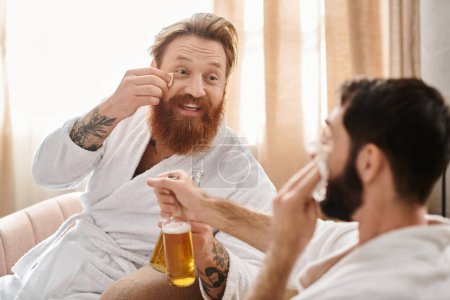 Ein bärtiger Mann und sein Begleiter genießen einen entspannten Moment zusammen, einer hält ein Bier.