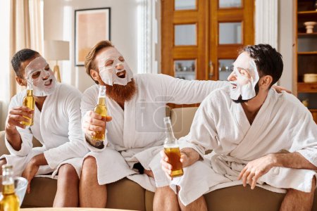 Three diverse, cheerful men in bathrobes relax happily perched on a couch, sharing a moment of friendship and joy.