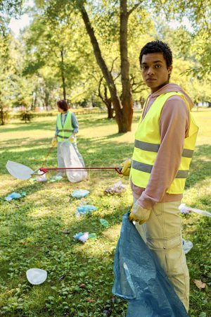 Socially active diverse couple cleaning a park together.
