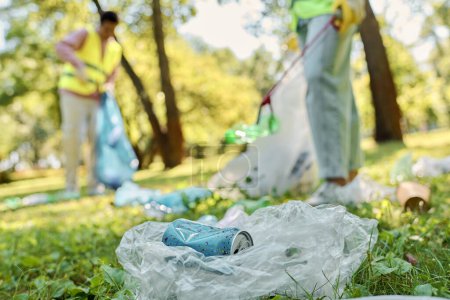 Ein sozial aktives, vielfältiges Liebespaar in Sicherheitswesten und Handschuhen, das Müll in einem Park beseitigt und Umweltschutz und kommunales Engagement fördert.