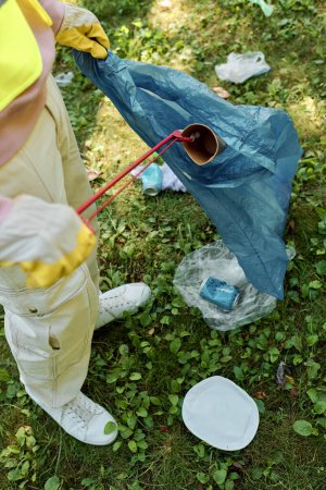 Photo for African american man cleaning park and holding blue bag next to his wife - Royalty Free Image