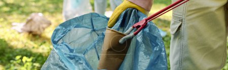 Afrikanischer Mann mit blauer Tasche wirft Müll hinein