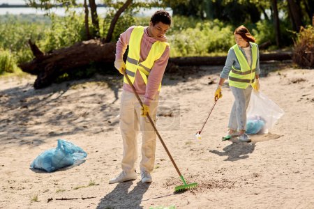 Photo for A diverse and loving couple, clad in safety vests and gloves, stand in the sand, passionately cleaning up a park together. - Royalty Free Image