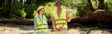 A diverse, socially active couple, in safety vests and gloves, standing together in dirt, cleaning a park with care.
