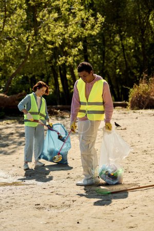A socially active, diverse, loving couple in safety vests and gloves cleaning a sandy beach together.