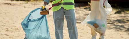 Téléchargez les photos : Une femme vêtue d'un gilet jaune vif tenant un sac bleu, nettoie le parc avec son partenaire afro-américain socialement actif. - en image libre de droit