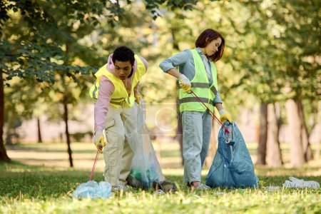 A loving, diverse couple in safety vests and gloves stand in the grass, cleaning the park together.