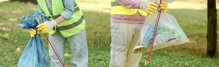Photo for Two diverse people in safety vests and gloves standing in grass, showing love and care for the park environment. - Royalty Free Image