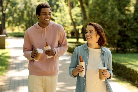 A diverse, loving couple walking down a scenic sidewalk in vibrant attire, enjoying each others company.