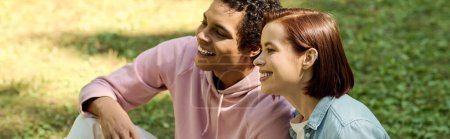 Ein liebendes Paar in lebendiger Kleidung sitzt eng nebeneinander in einem Park und strahlt Glück und Verbundenheit aus.