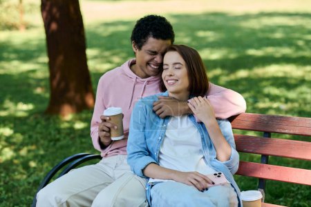 Un couple diversifié en tenue vibrante se détend sur un banc de parc, profitant de l'autre compagnie par une journée ensoleillée.