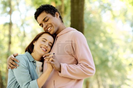 A diverse couple in colorful attire sharing a warm hug in a park setting, expressing love and connection.