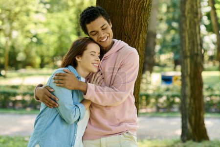 Foto de Un hombre en traje vibrante abraza a una mujer con amor, rodeado por la belleza de un parque. - Imagen libre de derechos